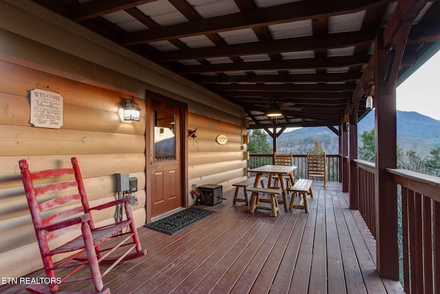 wooden deck with a mountain view and a ceiling fan