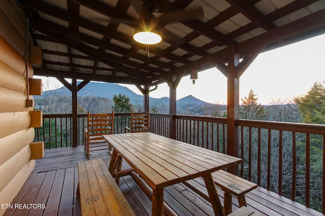 wooden terrace featuring a mountain view and outdoor dining space