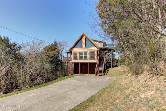 view of front of home featuring log siding and stairway