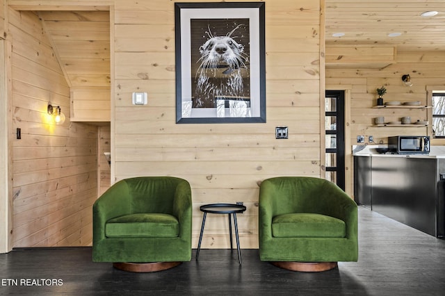 living area with lofted ceiling, dark wood-type flooring, wood ceiling, and wood walls