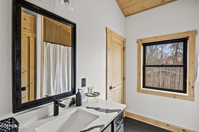 bathroom featuring lofted ceiling, wood ceiling, wood finished floors, and vanity