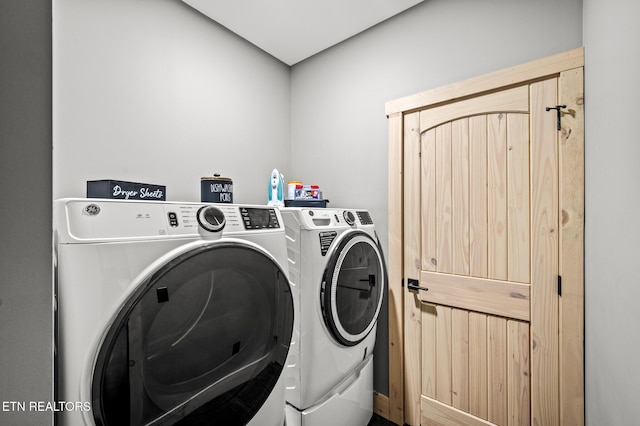 clothes washing area with washer and clothes dryer and laundry area