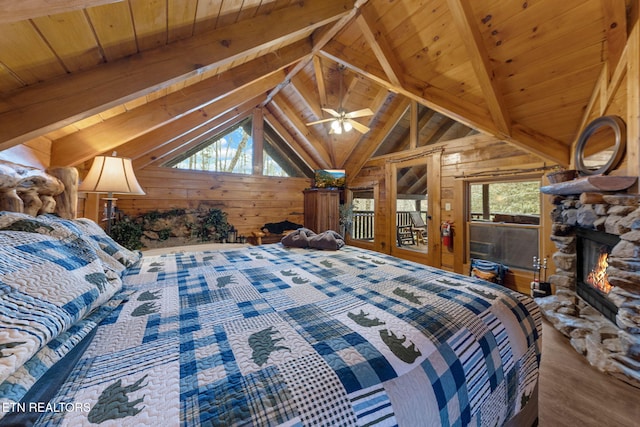 unfurnished bedroom featuring lofted ceiling with beams, multiple windows, a stone fireplace, and wood walls