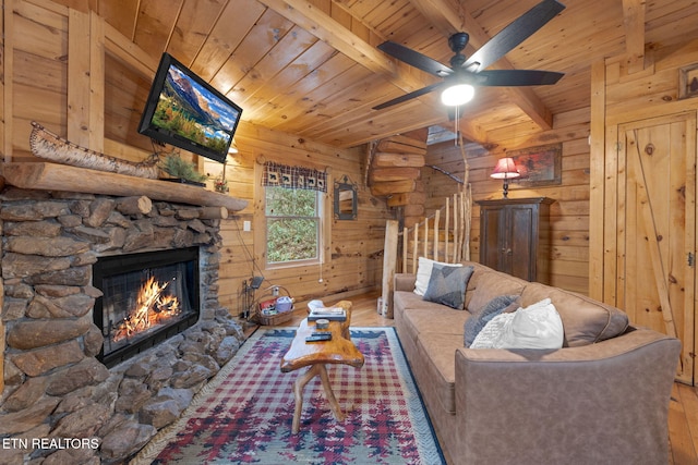 living room featuring wooden walls, wood ceiling, lofted ceiling with beams, a fireplace, and wood finished floors