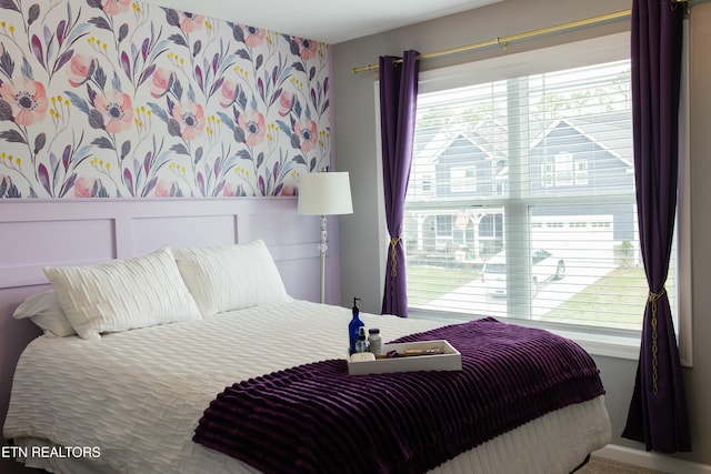 bedroom featuring a wainscoted wall and wallpapered walls