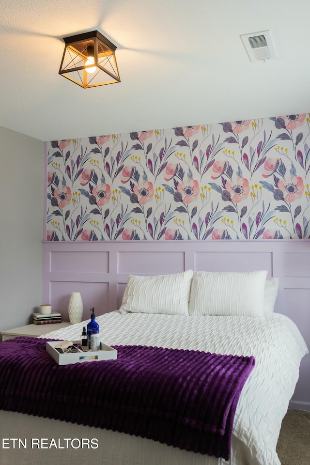 bedroom with visible vents and carpet flooring