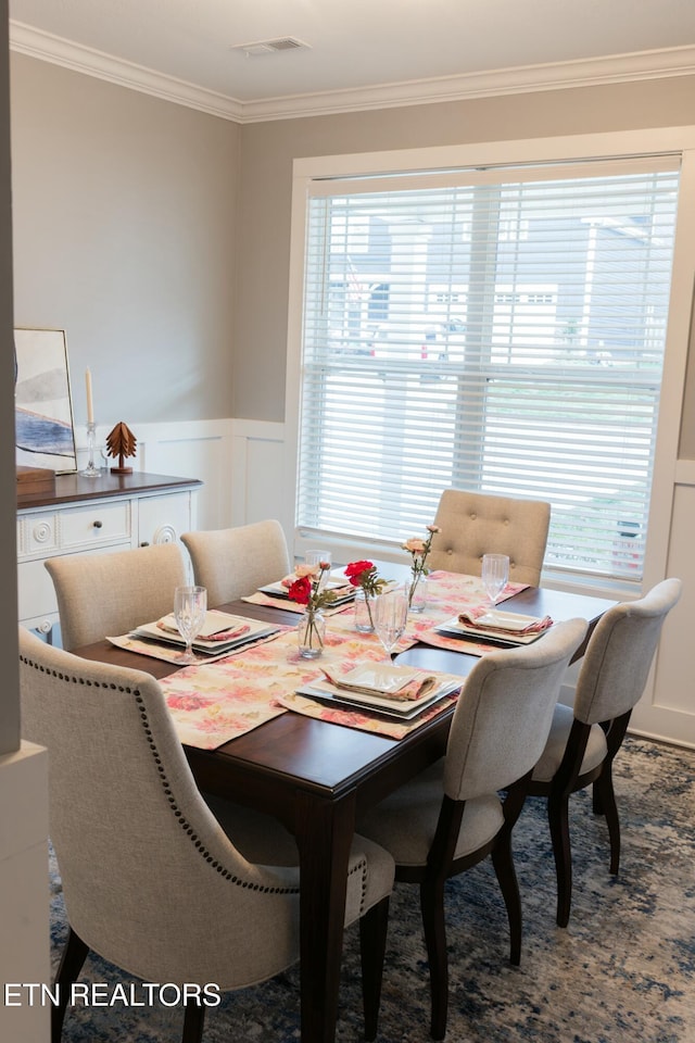 dining area with visible vents, wainscoting, and crown molding