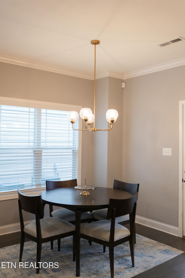 dining area featuring visible vents, baseboards, ornamental molding, wood finished floors, and a notable chandelier