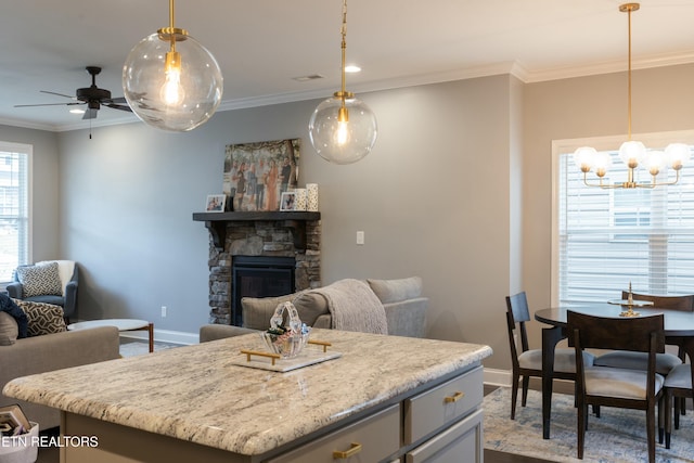 kitchen featuring crown molding, ceiling fan with notable chandelier, open floor plan, and baseboards