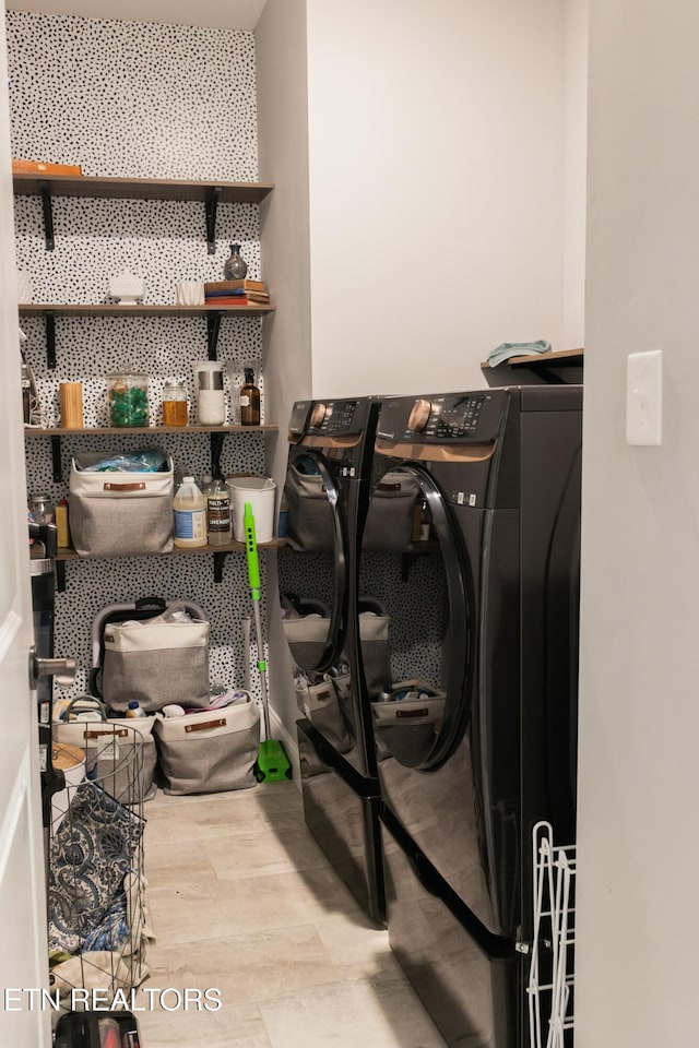 washroom with laundry area, washer and dryer, and wood finished floors