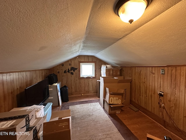 bonus room with wood finished floors, a textured ceiling, wood walls, and vaulted ceiling