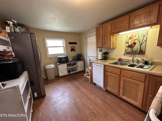 kitchen featuring a sink, dark wood finished floors, white dishwasher, and light countertops