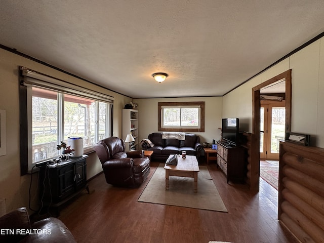 living room featuring plenty of natural light, ornamental molding, and wood finished floors