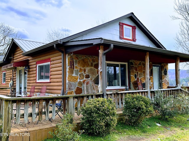 view of property exterior with stone siding and a porch