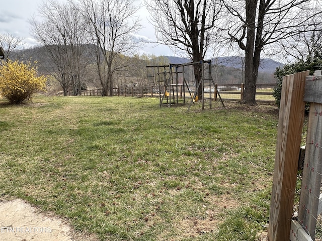 view of yard featuring fence and a mountain view