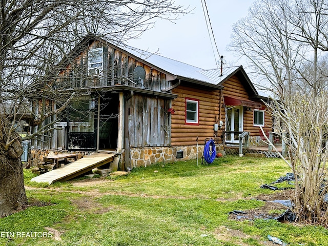 view of front facade with a front lawn, crawl space, and metal roof