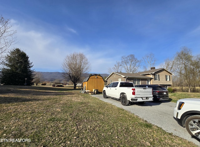 exterior space featuring an outbuilding, a storage unit, and driveway