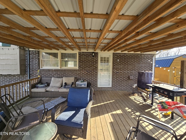 wooden terrace featuring an outdoor structure and a storage unit