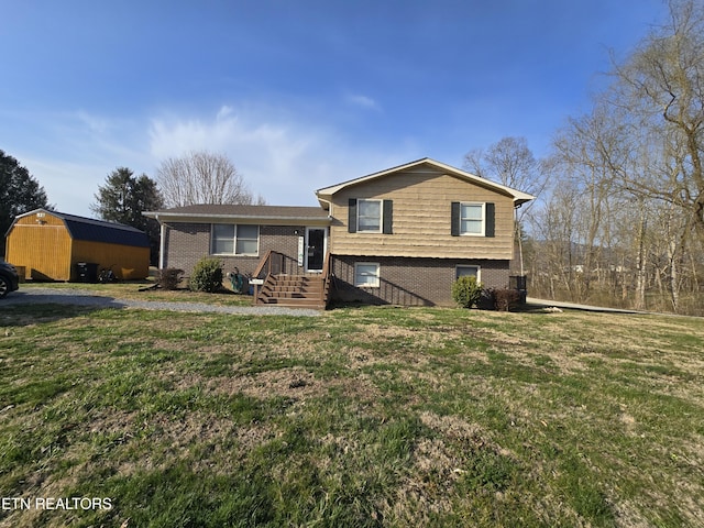 split level home with a front yard and brick siding