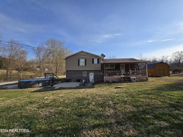 rear view of property with an outdoor pool, an outdoor structure, a storage unit, a deck, and brick siding