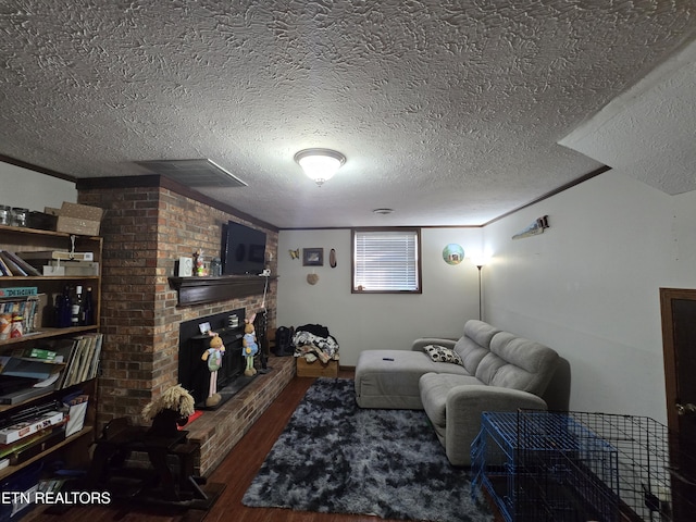 living area with wood finished floors, visible vents, and a textured ceiling