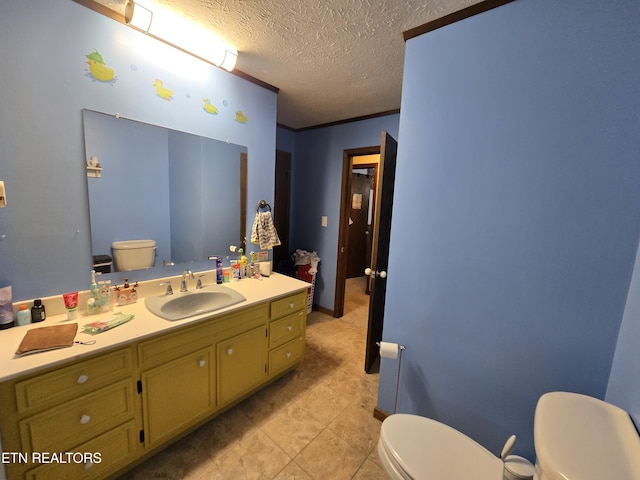 half bathroom featuring a textured ceiling, toilet, vanity, and ornamental molding