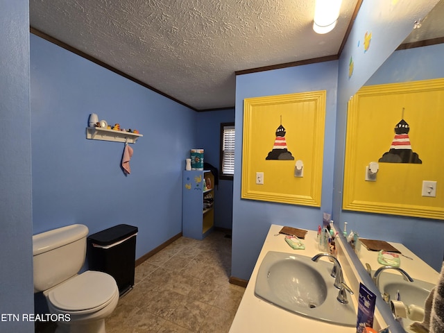 bathroom featuring toilet, ornamental molding, a textured ceiling, baseboards, and vanity