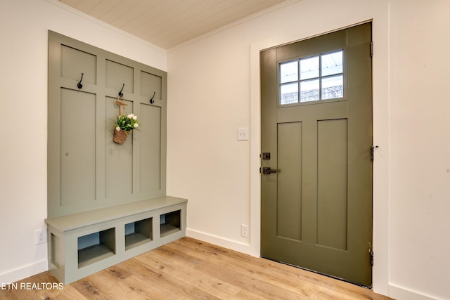 mudroom with baseboards, crown molding, and light wood finished floors