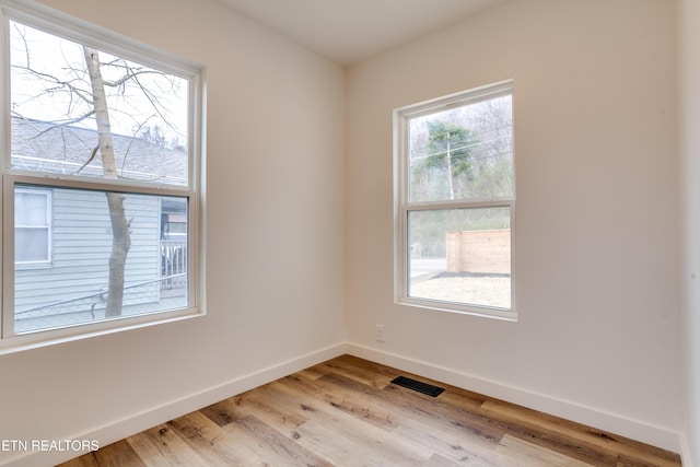 unfurnished room featuring visible vents, baseboards, and light wood finished floors