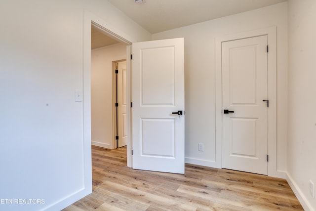 unfurnished bedroom featuring baseboards and light wood-style floors