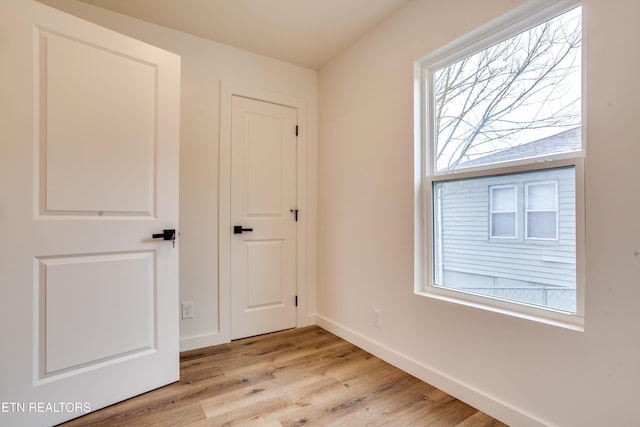 unfurnished bedroom featuring light wood-type flooring and baseboards