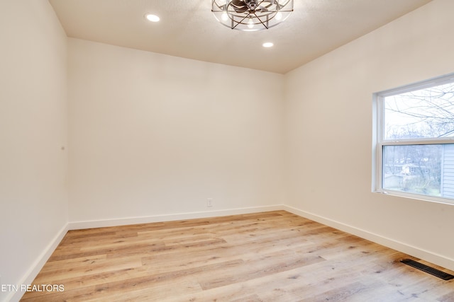 unfurnished room with light wood finished floors, visible vents, recessed lighting, and baseboards