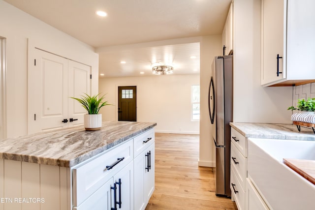 kitchen with recessed lighting, white cabinetry, light wood-type flooring, and freestanding refrigerator