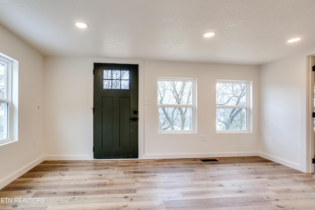 foyer featuring recessed lighting, baseboards, a textured ceiling, and wood finished floors