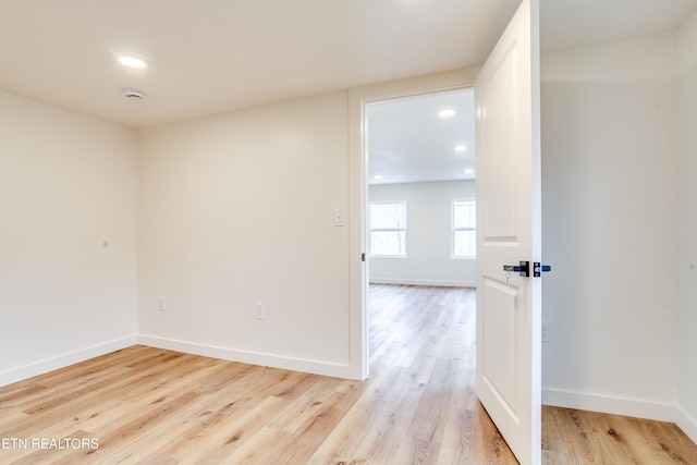 unfurnished room with light wood-style flooring, recessed lighting, and baseboards