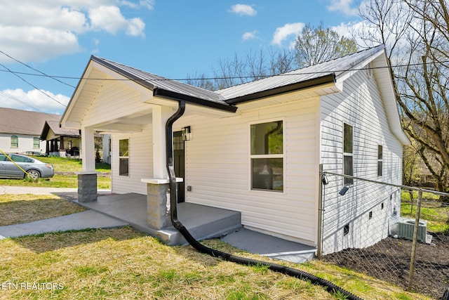 view of home's exterior featuring a lawn, crawl space, central air condition unit, and metal roof
