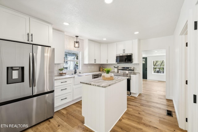 kitchen featuring a sink, white cabinets, visible vents, and stainless steel appliances