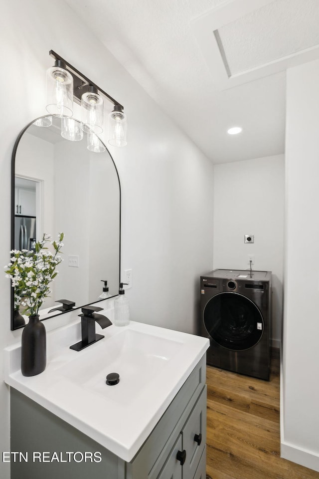 bathroom featuring washer / clothes dryer, wood finished floors, and vanity