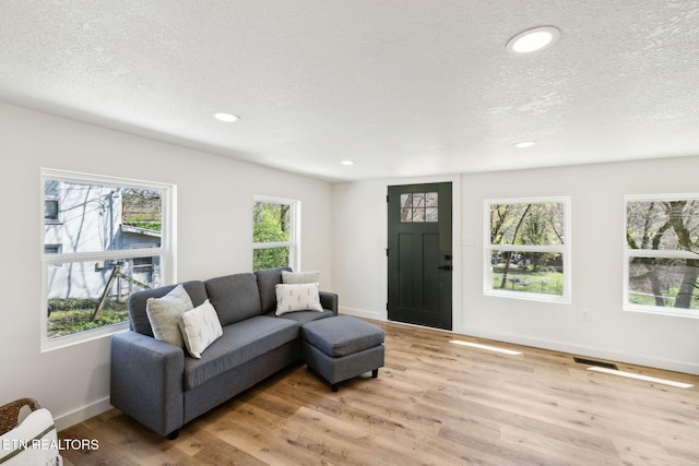 living room featuring visible vents, wood finished floors, and plenty of natural light