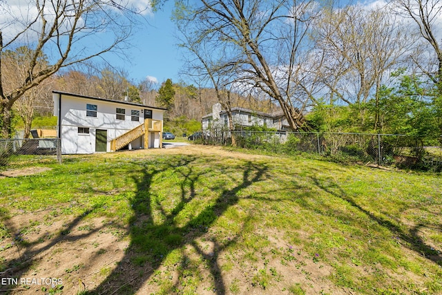 view of yard with a fenced backyard and stairs