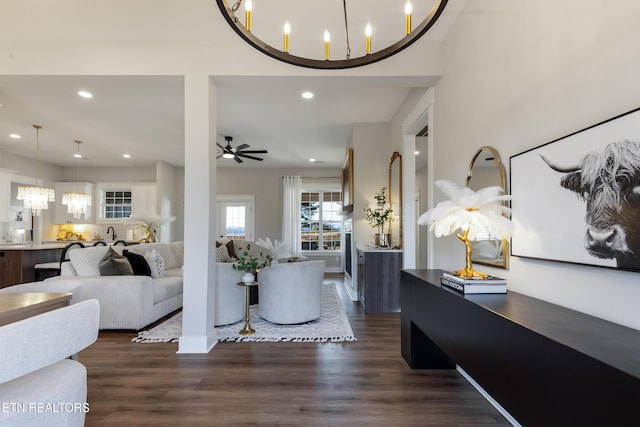 foyer with ceiling fan with notable chandelier, dark wood-type flooring, and recessed lighting