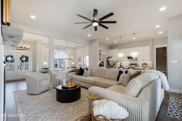 living room with stairs, wood finished floors, recessed lighting, and ceiling fan with notable chandelier