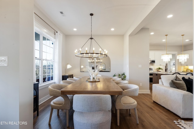 dining area featuring dark wood finished floors, a notable chandelier, and baseboards