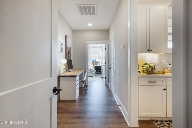 hall featuring dark wood-style floors and visible vents