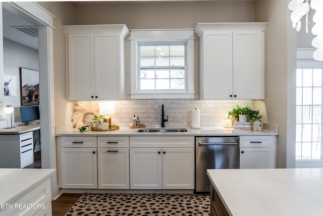 kitchen with dishwasher, white cabinets, tasteful backsplash, and a sink