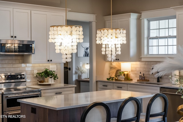 kitchen with a kitchen bar, appliances with stainless steel finishes, and light countertops