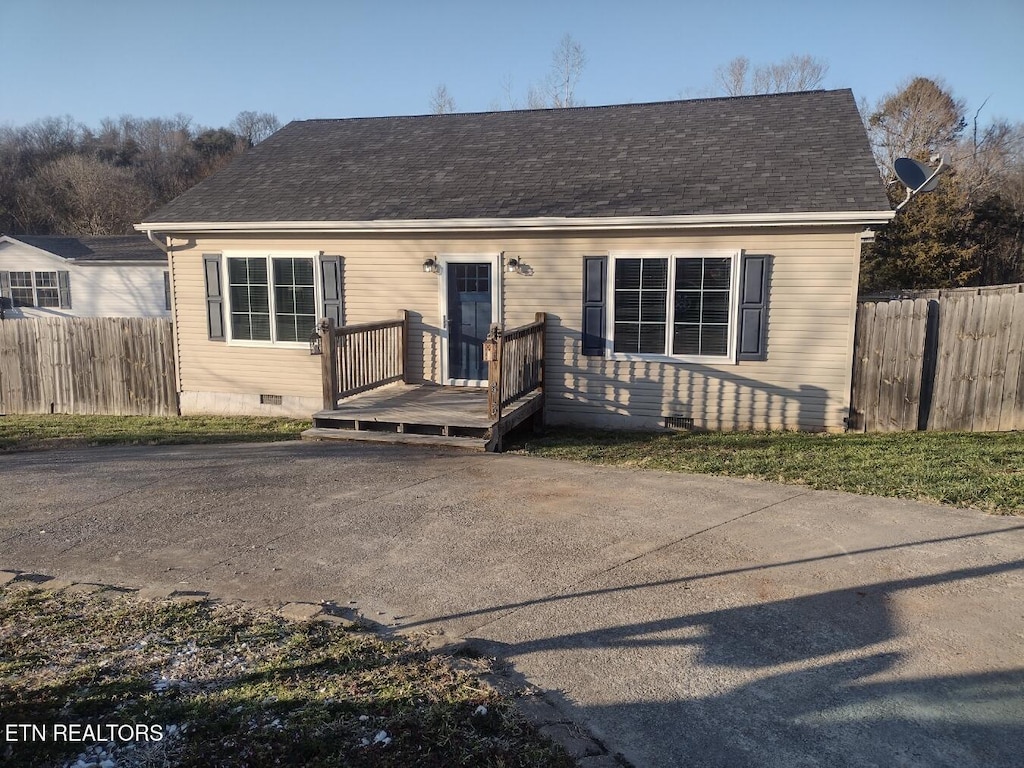 view of front facade featuring a shingled roof, a wooden deck, fence, and crawl space