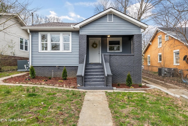 bungalow featuring a front lawn, central AC, and fence