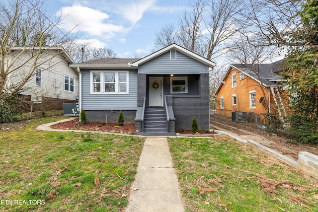 bungalow-style home featuring central AC unit, a front lawn, and fence