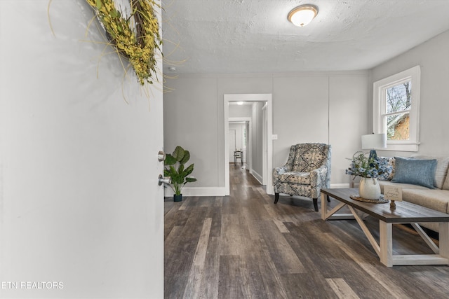 interior space with a textured ceiling, baseboards, and wood finished floors